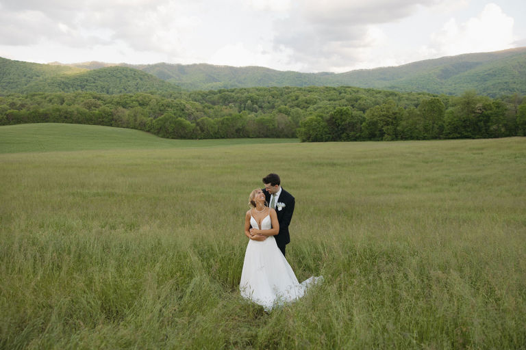 A couple in the tall-grass field, the Smoky Mountains beyond