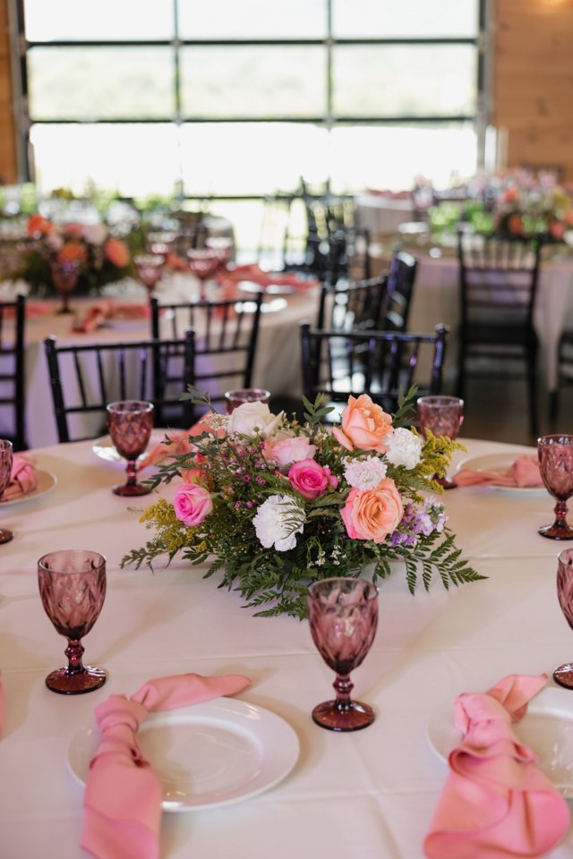 A reception table laid with florals and pink glassware